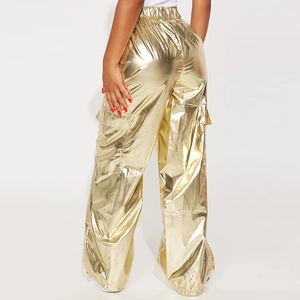 Detail of golden metallic cargo pants featuring elastic waist and large side pockets