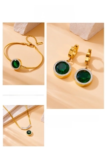 Detail of vintage gold jewelry set with round green emerald-cut stones and zircon halo