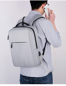 Detailed close-up of the integrated USB charging port on the gray laptop backpack side