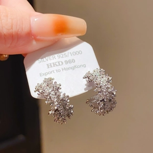 Gros plan de boucles d'oreilles C en argent avec zircons sur carte produit en argent S925