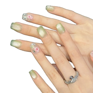 Unghie finte cat-eye verdi corte con delicati fiori secchi rosa e decorazioni in strass