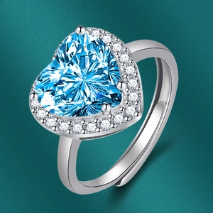 Vue macro d'une bague coeur en zircon bleu avec cristaux halo et anneau argenté ajustable
