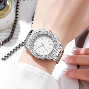 Close-up of stylish silver quartz watch with diamond bezel on woman wrist