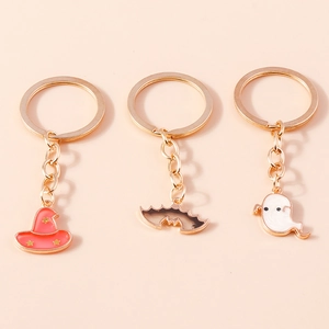 Detail view of Halloween keychains featuring a red wizard hat, brown bat, and white ghost