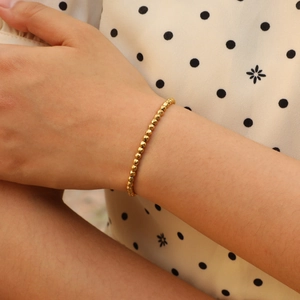 Elegant gold faceted bead bracelet for women featuring glossy metallic texture on wrist