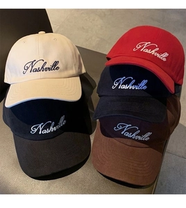 Detail view showing assorted cotton baseball caps with Nashville embroidery in multiple colors