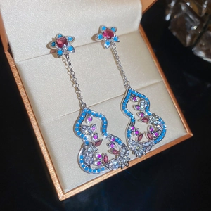 Detail von silbernen Kürbis-Quasten-Ohrringen mit blauen und rosa Zirkonia in Box