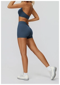 Dettaglio dei pantaloncini da yoga a vita alta arricciati e del reggiseno sportivo blu