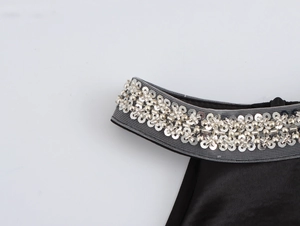 Close-up of elegant halter neckline with silver sequins and beadwork on black satin