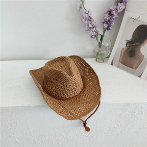 Close-up of caramel straw cowboy hat featuring breathable mesh weave and tassel cord