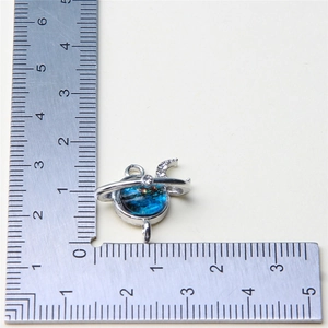 Macro view of blue and silver star planet charm with measurement scale showing 15mm size