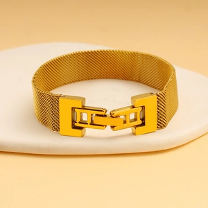 Detail of golden stainless steel mesh bracelet with mechanical square buckle on stone