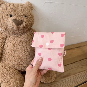 Detailed view of pink heart canvas tote bag with snap button closure and woven brand tag