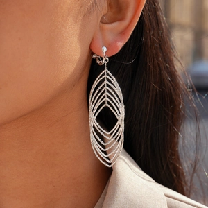 Close-up of geometric hollow oval silver clip-on earrings with layered metal texture