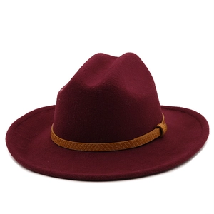 Detail of burgundy wool fedora hat with woven brown leather band and textured finish