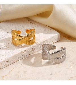 Detailed close-up of gold and silver crossover rings with textured finish on stone base