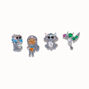 Detailed macro shot of zircon-inlaid animal and astronaut earrings in silver finish