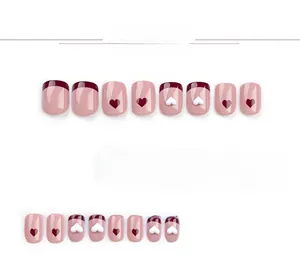 Detail of red French heart and bow press-on nails set with 3D resin charms