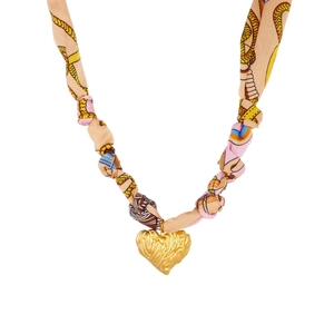 Detailed macro view of gold-plated heart pendant with vintage floral silk ribbon pattern