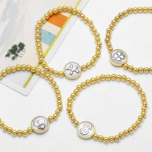 18k gold plated beaded bracelets with balloon dog, heart, and clover charms on a white background