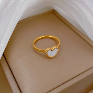 Close-up of heart-shaped gold ring with white mother of pearl inlay in a jewelry box