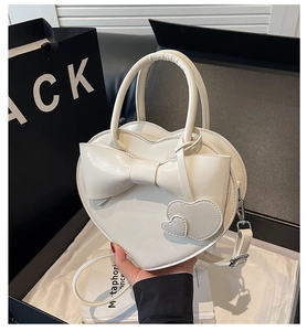 Sac à main blanc en forme de cœur avec nœud présenté dans un emballage cadeau