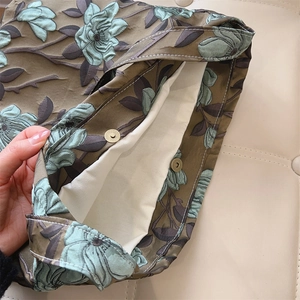 Dettaglio della trama jacquard floreale e della chiusura magnetica in metallo