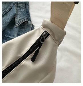 Detail of smooth black zipper with long pull cord and wide strap on white tote bag