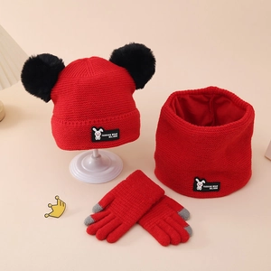Detailed view of red knitted hat set with furry pom-poms and touch-screen gloves