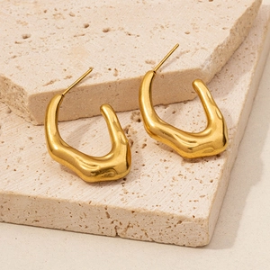 Detailed shot of gold-plated 304 stainless steel lava earrings on a beige stone base