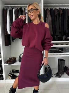 Detail of burgundy two-piece knit set featuring off-shoulder top and high waist skirt