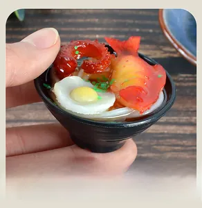 Detailed macro view of a miniature Japanese ramen bowl keychain with egg and shrimp