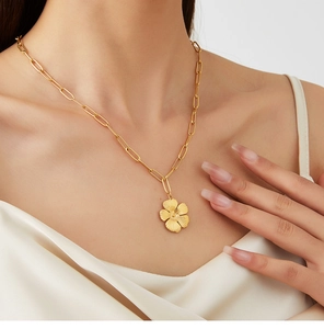 Detail of vintage gold flower pendant necklace with elegant paperclip chain on model