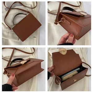 Detail view of brown leather crossbody bag showing internal capacity and metal fittings