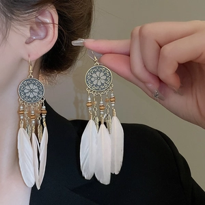 Bohemian dangle earrings with bronze carvings, wood beads, and white feather tassels