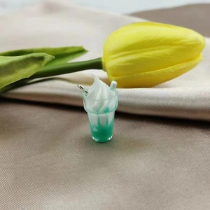 Miniature mint ice cream sundae charm on elegant fabric with a decorative tulip detail