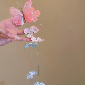 Detail of fabric butterfly hair clip with floral tassel and pearl embellishments
