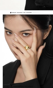 Macro shot of gold wide band starburst ring worn by model in black suit for a bold look