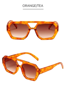 Detail view of stylish orange geometric sunglasses with tea gradient lenses in high quality