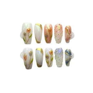 Unghie finte fatte a mano con tulipani 3D, perle e glitter su sfondo bianco puro