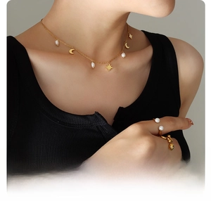 Detail of 18k gold plated surgical titanium necklace with pearl and moon pendants