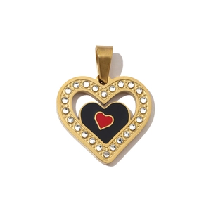 Detailed view of a gold heart pendant with black and red inlay and white rhinestones