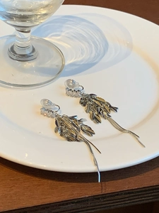 Détail des boucles d'oreilles à pampilles en épi argenté avec zircons sur plat
