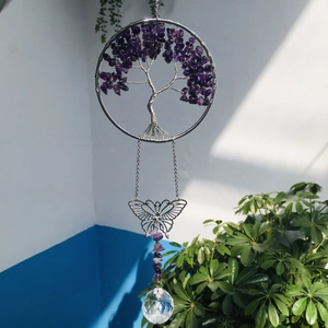 Detail of tree of life suncatcher with purple stones and a clear crystal prism ball