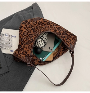 Detail showing the large leopard print tote bag interior capacity with everyday essentials