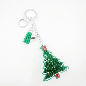 Close-up of sparkling Christmas tree keychain with green rhinestones and a silk tassel