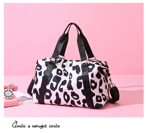 Detail shot of leopard print travel bag with reinforced handles and golden hardware
