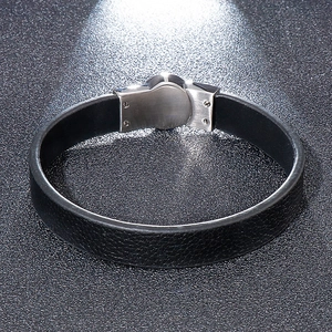 Detailed close-up of the silver stainless steel clasp on a black braided leather bracelet