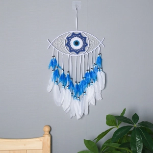 Detail of handmade evil eye dreamcatcher featuring blue feathers and woven beads