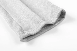 Vue macro du tissu en maille gris chiné montrant la finition couture à double aiguille